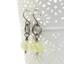 Silver earrings with translucent pale Yellow beads on a white background