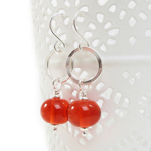 Orange Bead earrings with silver rings on a white background