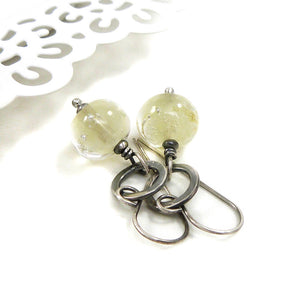 Silver earrings with translucent pale Yellow beads on a white background