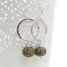 Silver Circle and speckled glass bead drop earrings on a white background