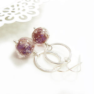 Silver earrings with pink bubble bead accents on a white background