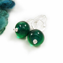 Green bead earrings with silver hooks on a white background