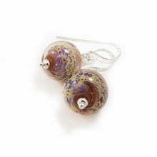 Pair of glass bead earrings with silver hooks on a white background