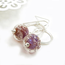 Silver earrings with pink bubble beads on a white background