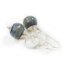 Pair of silver earrings with blue glass beads on a white background