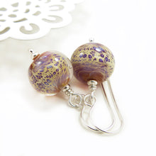 Pair of glass bead earrings with silver hooks on a white background