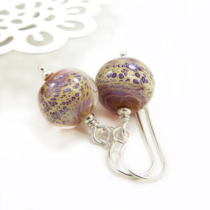 Pair of glass bead earrings with silver hooks on a white background