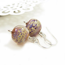 Pair of glass bead earrings with silver hooks on a white background