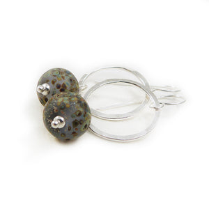 Silver Circle and speckled glass bead drop earrings on a white background
