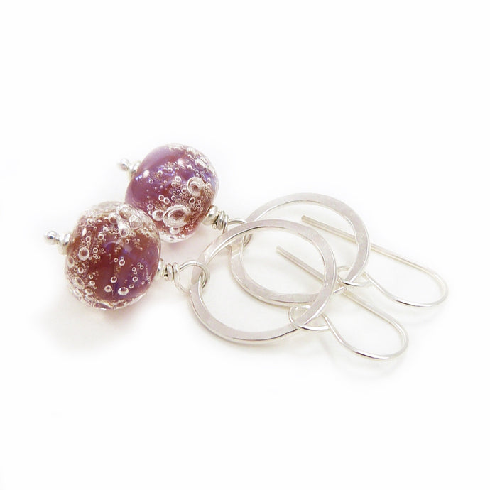 Silver earrings with pink bubble bead accents on a white background