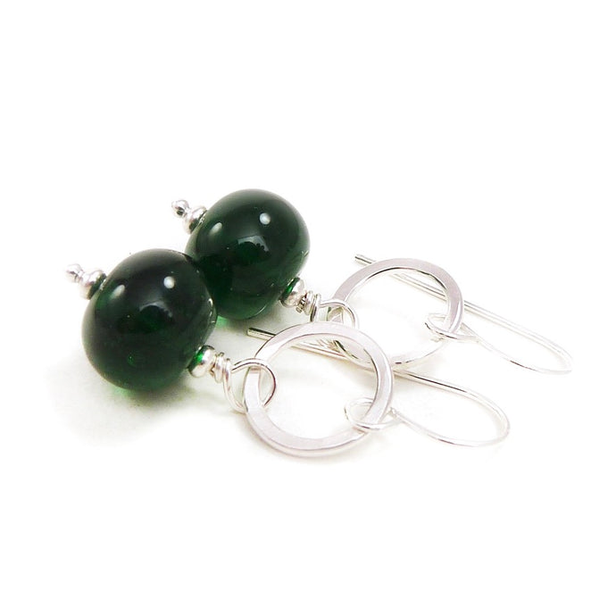 Green beaded earrings with silver hooks on a white background