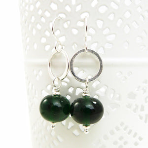Green beaded earrings with silver hooks on a white background