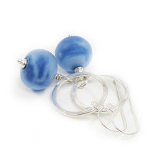 Earrings with blue beads and silver loops on a white background