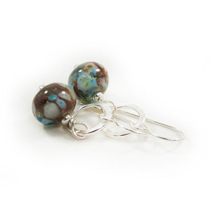 Pair of glass bead earrings with silver hooks on a white background