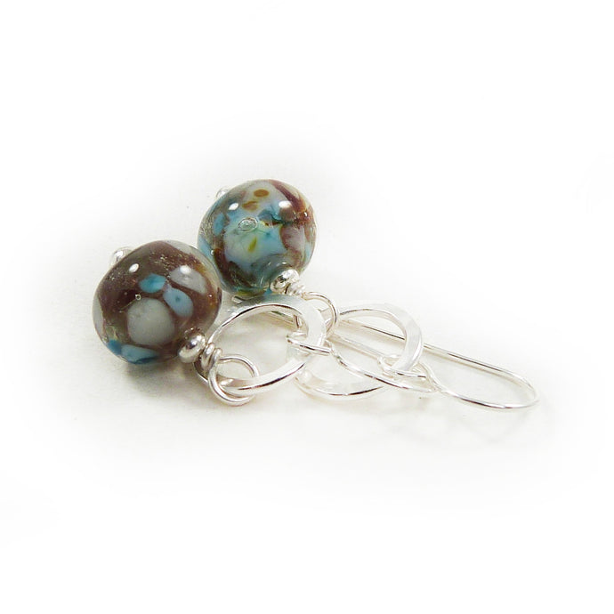 Pair of glass bead earrings with silver hooks on a white background