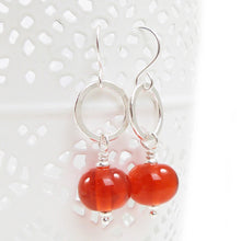 Orange Bead earrings with silver rings on a white background