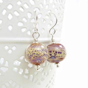 Pair of glass bead earrings with silver hooks on a white background