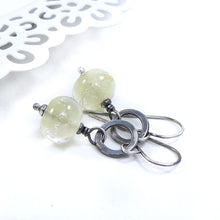 Silver earrings with translucent pale Yellow beads on a white background