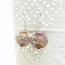 Pair of glass bead earrings with silver hooks on a white background