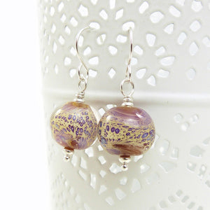 Pair of glass bead earrings with silver hooks on a white background