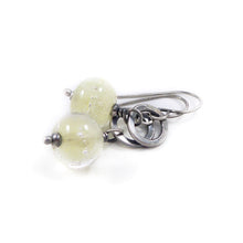Silver earrings with translucent pale Yellow beads on a white background