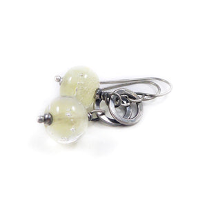 Silver earrings with translucent pale Yellow beads on a white background
