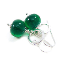 Green bead earrings with silver hooks on a white background