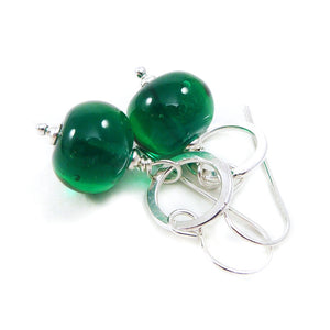 Green bead earrings with silver hooks on a white background
