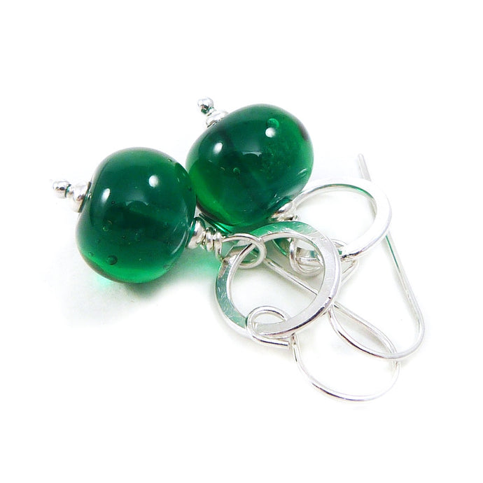 Green bead earrings with silver hooks on a white background
