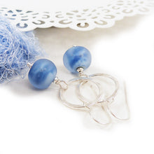 Blue glass bead earrings with silver loops on a white background