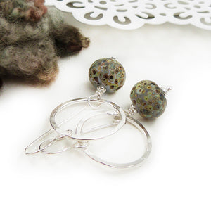 Silver Circle and speckled glass bead drop earrings on a white background