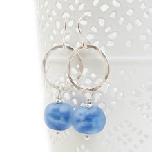 Silver hoop earrings with blue beads on a white background