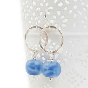 Silver hoop earrings with blue beads on a white background