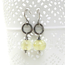 Silver earrings with translucent pale Yellow beads on a white background