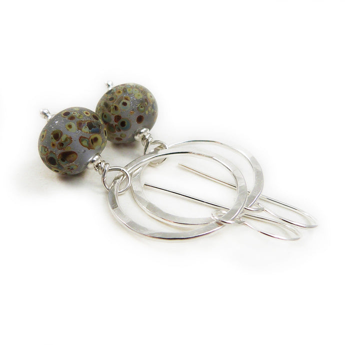 Silver Circle and speckled glass bead drop earrings on a white background