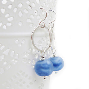 Silver earrings with blue beads on a white background