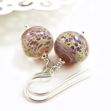 Pair of glass bead earrings with silver hooks on a white background