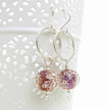 Silver earrings with pink bubble beads on a white background