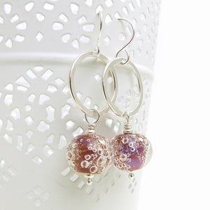 Silver earrings with pink bubble beads on a white background