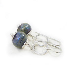 Pair of silver earrings with blue glass beads on a white background